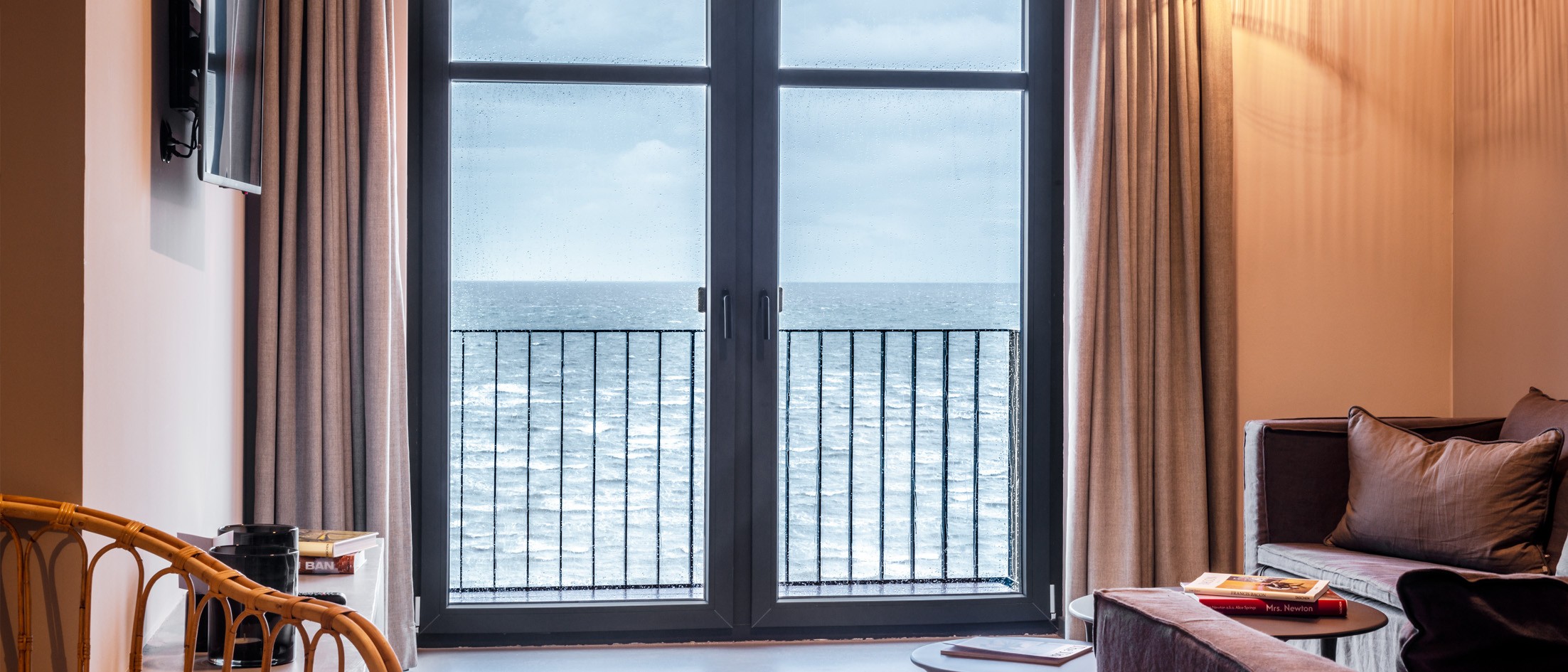 Innenraum mit dunklen Fensterrahmen und Blick auf das Meer